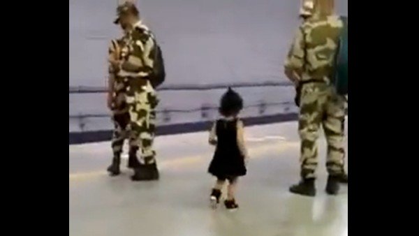 little girl touching an army personnel's feet 